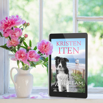 Mending his dream on an ereader, sitting next to a vase of flowers