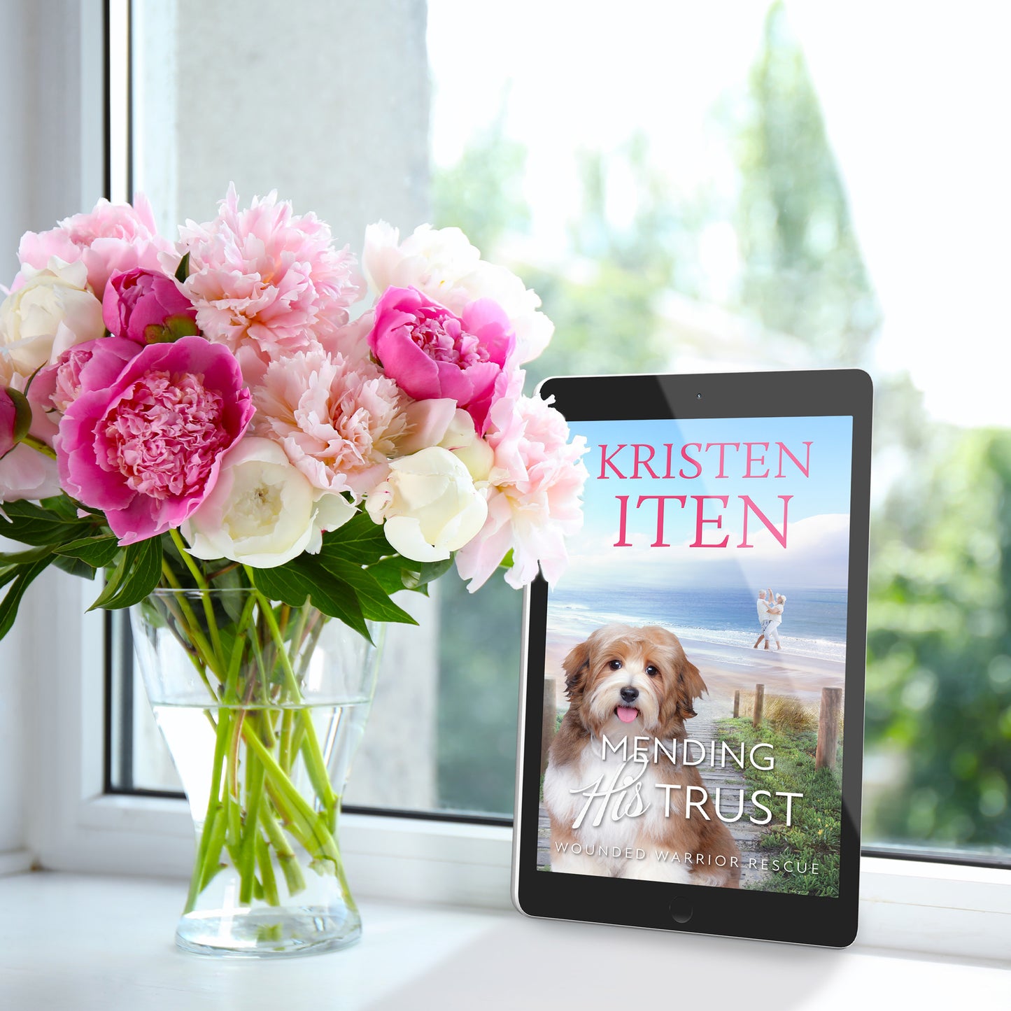 mending his trust on an e-reader, sitting on a windowsill, next to a vase of flowers
